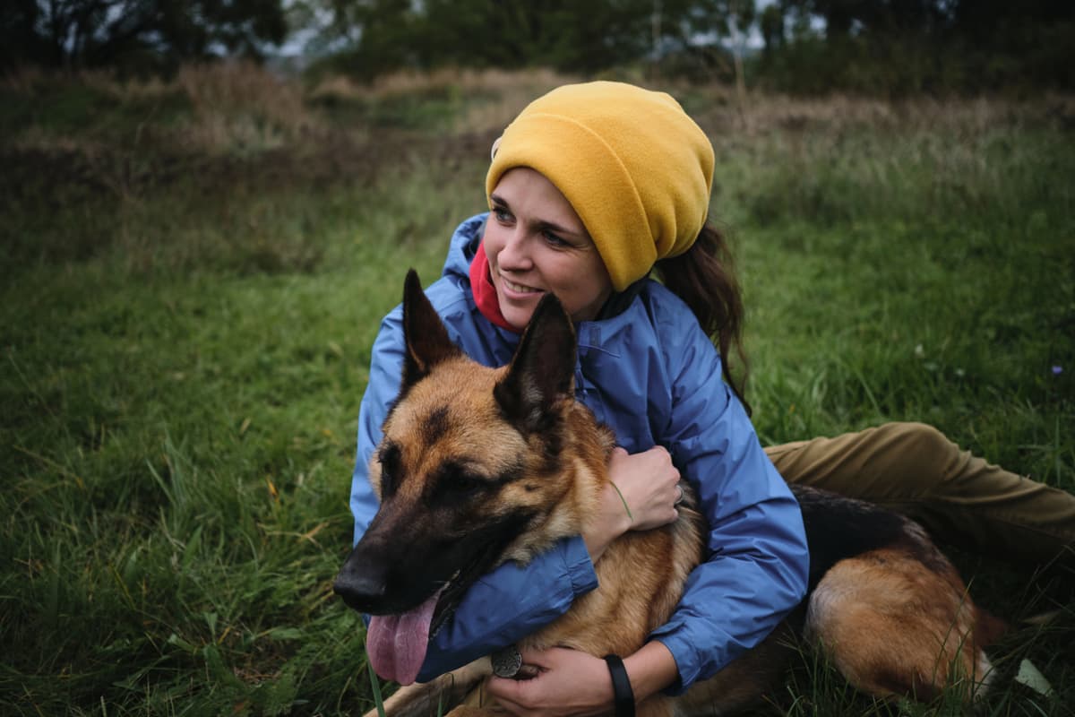 Woman hugging a German Shepherd in the grass